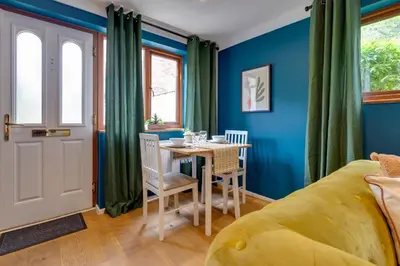 a bedroom with blue walls and a table with chairs at Fully refurbished 1 bedroom in Cambridge