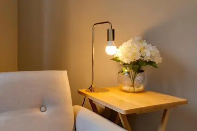 a vase of flowers on a table next to a lamp at Fully refurbished 1 bedroom in Cambridge