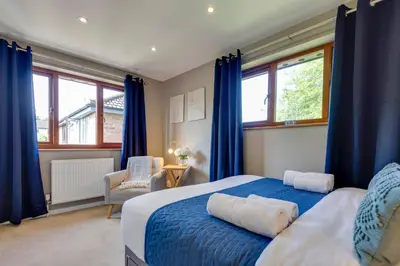 a bedroom with a blue bed with blue curtains at Fully refurbished 1 bedroom in Cambridge