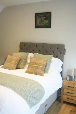 a bed with white sheets and pillows in a bedroom at The Red Cow in Heydon