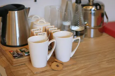 two white cups of coffee on a wooden table at The Red Cow in Heydon