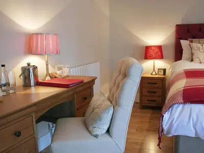 a bedroom with a desk with a chair and a bed at The Red Cow in Heydon