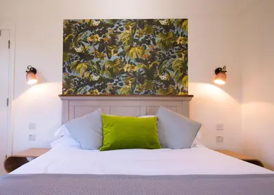 a bedroom with a bed with a green pillow on it at Longstowe Farmhouse in Longstowe