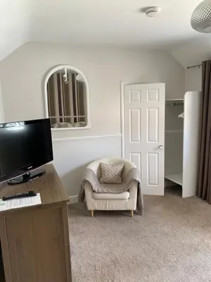 a living room with a tv and a chair and a door at Ship Stores B&B in Clare