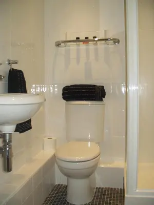 a white bathroom with a toilet and a sink at Ship Stores B&B in Clare