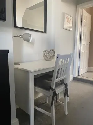 a white desk with a chair and a lamp at Eclipse Apartment No 1 in Newmarket