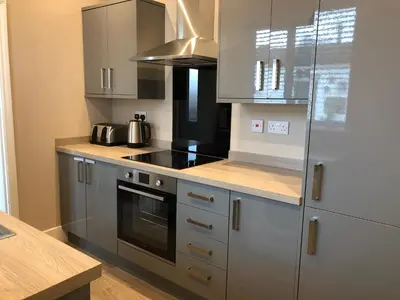 a kitchen with silver cabinets and a stove top oven at Eclipse Apartment No 1 in Newmarket