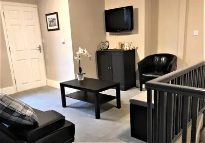 a living room with a tv and a table and chairs at Eclipse Apartment No 2 in Newmarket