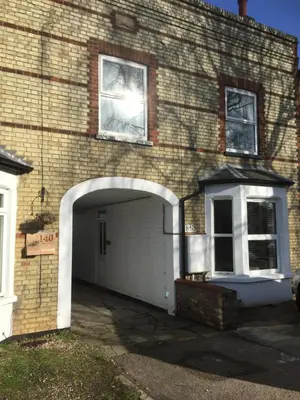 a brick building with a garage with a white door at Eclipse Apartment No 2 in Newmarket