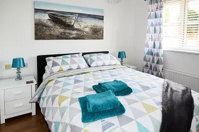 a bedroom with a bed with blue towels on it at Sunshine Corner in West Mersea