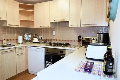 a kitchen with white cabinets and a counter top at Sunshine Corner in West Mersea
