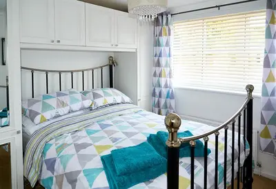 a bedroom with a bed and a window at Sunshine Corner in West Mersea