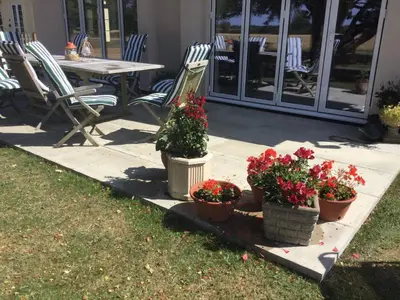 a patio with three potted plants and a table and chairs at Eight ball house in Southburgh