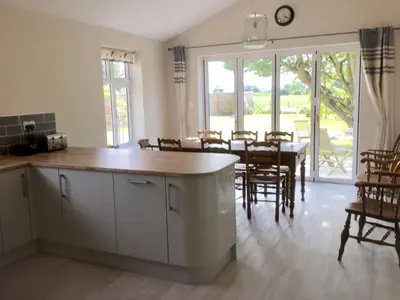 a kitchen and dining room with a table and chairs at Eight ball house in Southburgh