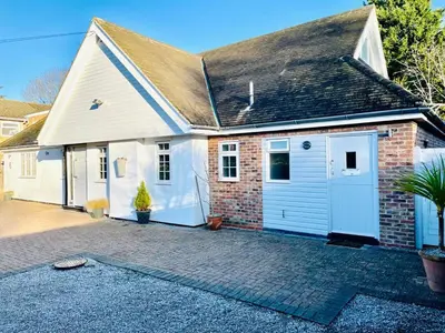 a brick house with a garage and a driveway at The Thorpe Guesthouse in Huntingdon