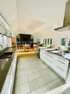 a large kitchen with white appliances and a dining room at The Thorpe Guesthouse in Huntingdon