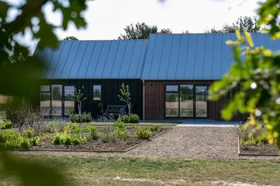 a house with a blue roof and a garden at The Fieldbarns at Bullocks Farm in Bishops Stortford