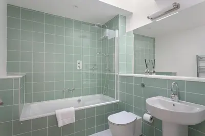 a bathroom with a tub and a toilet and a sink at The Fieldbarns at Bullocks Farm in Bishops Stortford