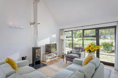 a living room with two couches and a tv at The Fieldbarns at Bullocks Farm in Bishops Stortford