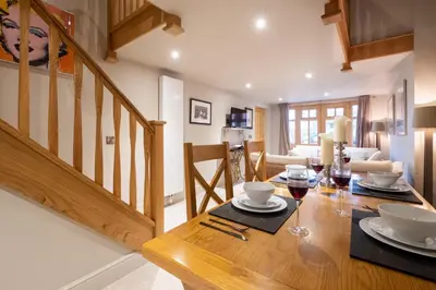 a dining room with a wooden table with glasses of wine at Church Farm Lodge in Aldeburgh