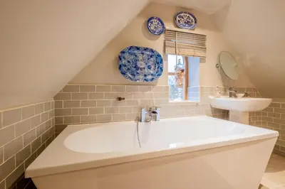 a bathroom with a large tub and a sink at Church Farm Lodge in Aldeburgh