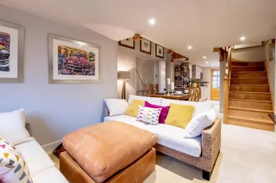 a living room with a couch and a stool at Church Farm Lodge in Aldeburgh