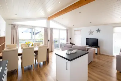 a kitchen and living room with a table and chairs at Horizon Lodge in Sizewell
