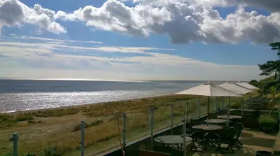 a row of tables with umbrellas and the ocean at Horizon Lodge in Sizewell