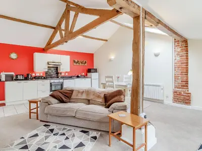 a living room with a couch and a kitchen at The Hen House in Diss