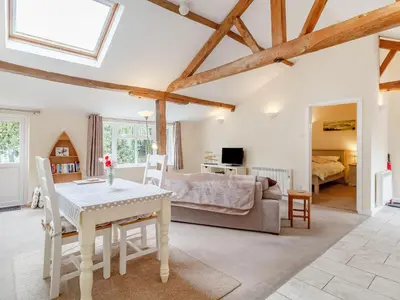 a living room with a table and a bedroom at The Hen House in Diss
