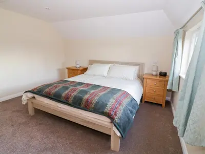 a bedroom with a bed and two night stands at The Granary in Halstead
