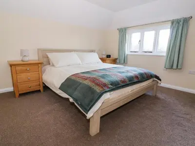 a bedroom with a large bed and a window at The Granary in Halstead
