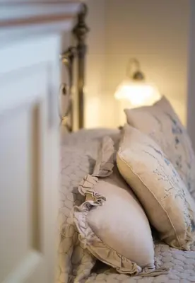 a bed with pillows and a lamp on it at Quavers Rest - quintessential little home & hot tub available ! in Rushford