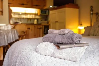 a pile of towels sitting on top of a bed at Quavers Rest - quintessential little home & hot tub available ! in Rushford