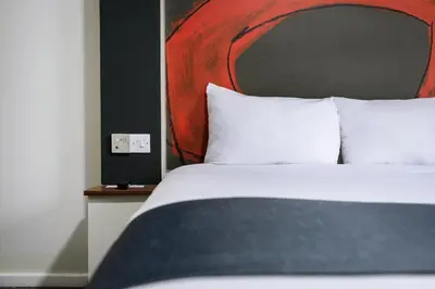 a bed with white pillows in a hotel room at Ramada London Stansted Airport in Stansted Mountfitchet