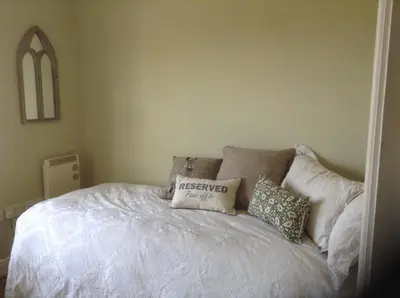 a bedroom with a white bed with pillows on it at Little Bury Barn in Bury Saint Edmunds