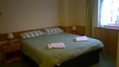 a bedroom with a bed with two towels on it at Carlton Lodge in Cambridge