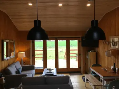 a living room with two black lights hanging from the ceiling at The Orchard Bramble Lodge in Hadleigh