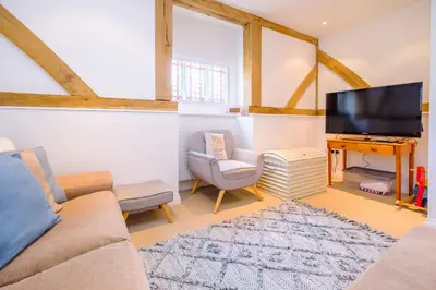 a living room with a couch and a tv at Meare House in Thorpeness