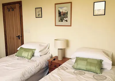 two beds sitting next to each other in a bedroom at Lackford Lakes Barns in Flempton