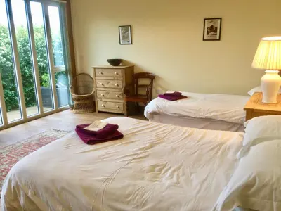 a bedroom with two beds and a dresser and a window at Lackford Lakes Barns in Flempton