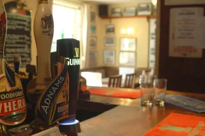 a bottle of beer sitting on top of a table at The Theberton Lion in Theberton