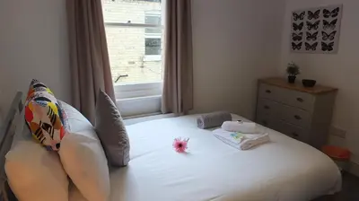 a bedroom with a white bed with a window at The Mill Suites - Tas Accommodations in Cambridge