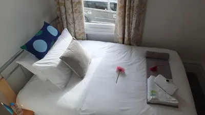 a bedroom with a white bed with pillows and a window at The Mill Suites - Tas Accommodations in Cambridge