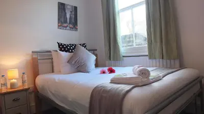 a small bedroom with a bed with a window at The Mill Suites - Tas Accommodations in Cambridge