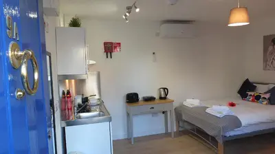 a small room with a bed and a sink at The Mill Suites - Tas Accommodations in Cambridge