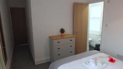 a bedroom with a bed and a dresser with a plant on it at The Mill Suites - Tas Accommodations in Cambridge