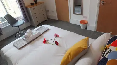 a bedroom with a white bed with flowers on it at The Mill Suites - Tas Accommodations in Cambridge
