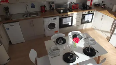 a kitchen with a table with plates and flowers on it at The Mill Suites - Tas Accommodations in Cambridge