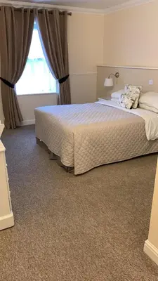 a bedroom with a large bed and a window at Hunters Meet in Bishops Stortford